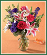 Bright hot pink roses, fragrant stargazer lilies, beautiful purple lisianthus and larkspur are arranged with silver dollar eucalyptus in an urn-shaped glass vase. This is a wonderful bouquet for anniversaries, birthdays, or any cause for celebration. Style of vase may vary.